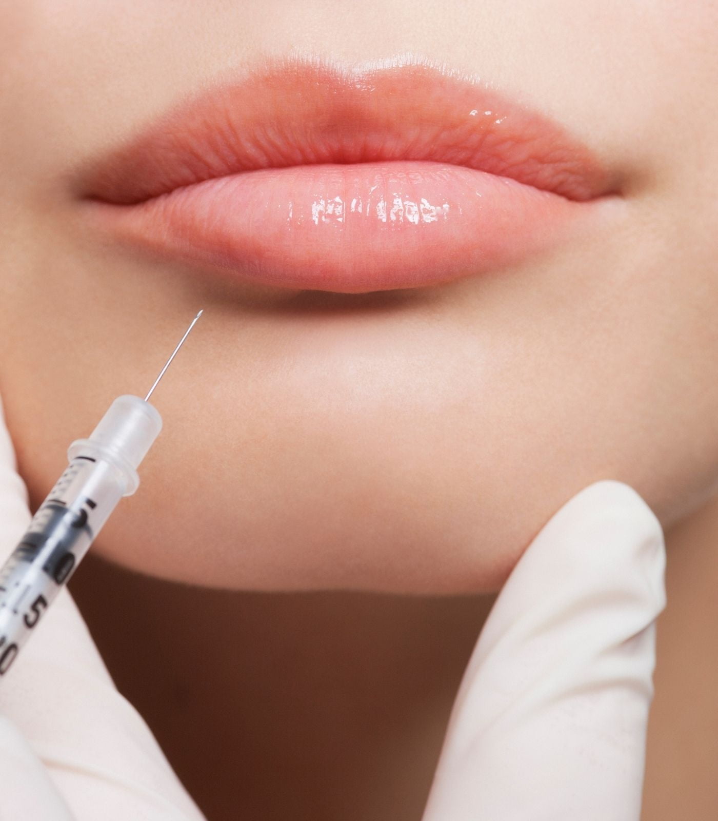 Close-up of woman lips being injected with lip fillers