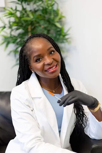 A smiling Dr Lian Peter posing in her cosmetic clinic in Ontario