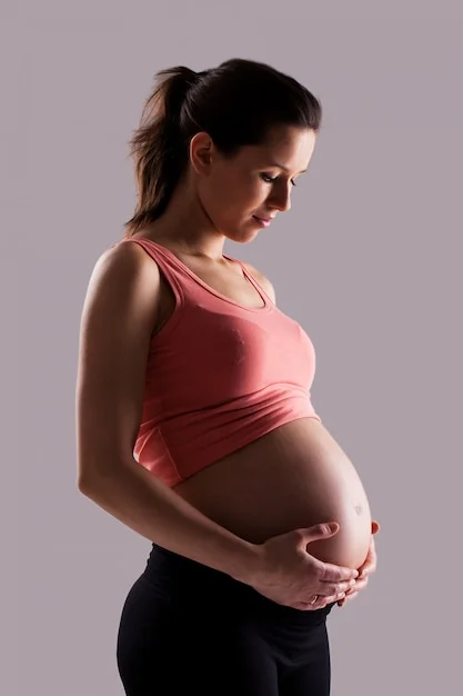 heavily pregnant white woman holding her protruding stomach with both hands