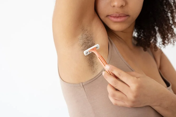 close up view of woman shaving armpit hair
